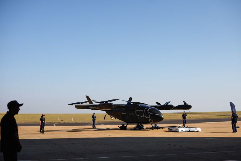 © Reuters. Employees work near the full-scale prototype of electric vertical take-off and landing (eVTOL) aircraft developed by Eve Air Mobility, an Embraer group company, as it is presented for the first time in Gaviao Peixoto, Brazil July 3, 2024. REUTERS/Amanda Perobelli