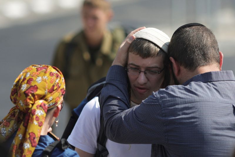 © Reuters. Netsach Cohen, an Orthodox Jewish man, says goodbye to his father Uri Cohen as he presents himself to serve in the Israel Defense Forces (IDF) amid the ongoing conflict between Hamas and Israel, in Tel Aviv, Israel, July 21, 2024. REUTERS/Ricardo Moraes