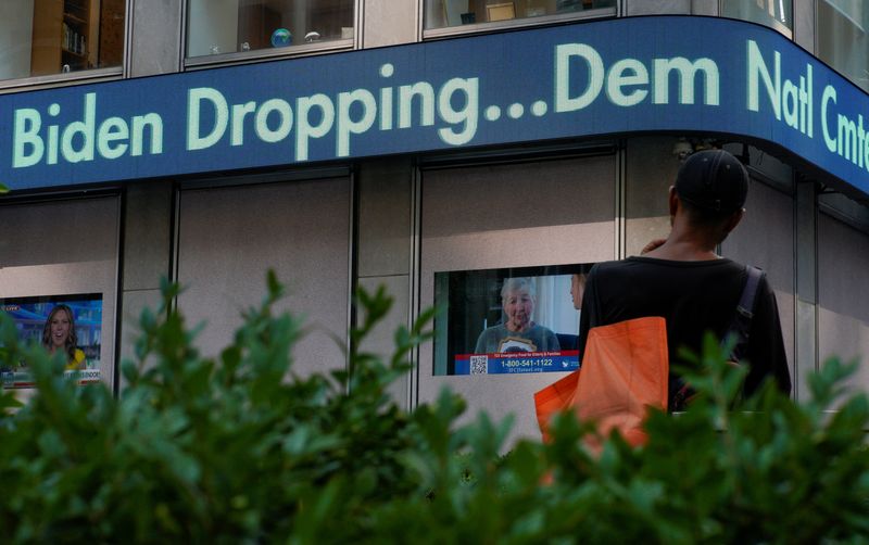 &copy; Reuters. A person looks at a news ticker, as news on U.S. President Joe Biden's announcement that he is dropping his reelection bid is displayed,  in the Manhattan borough of New York City, U.S., July 21, 2024.  REUTERS/Eduardo Munoz