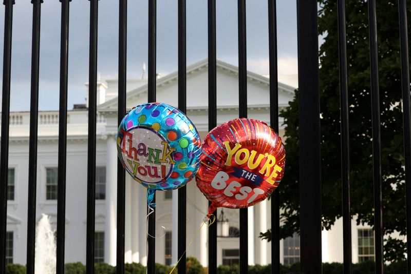 © Reuters. Balloons that were tied to the fence are pictured as people gather outside the White House after U.S. President Joe Biden announced he is stopping his bid for reelection, in Washington, D.C., U.S., July 21, 2024. REUTERS/Kevin Mohatt