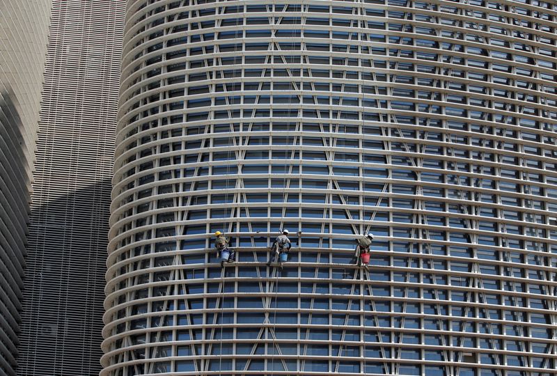 &copy; Reuters. FILE PHOTO: Workers clean the facade of a commercial building on the outskirts of Ahmedabad, India, January 29, 2018. REUTERS/Amit Dave/File photo