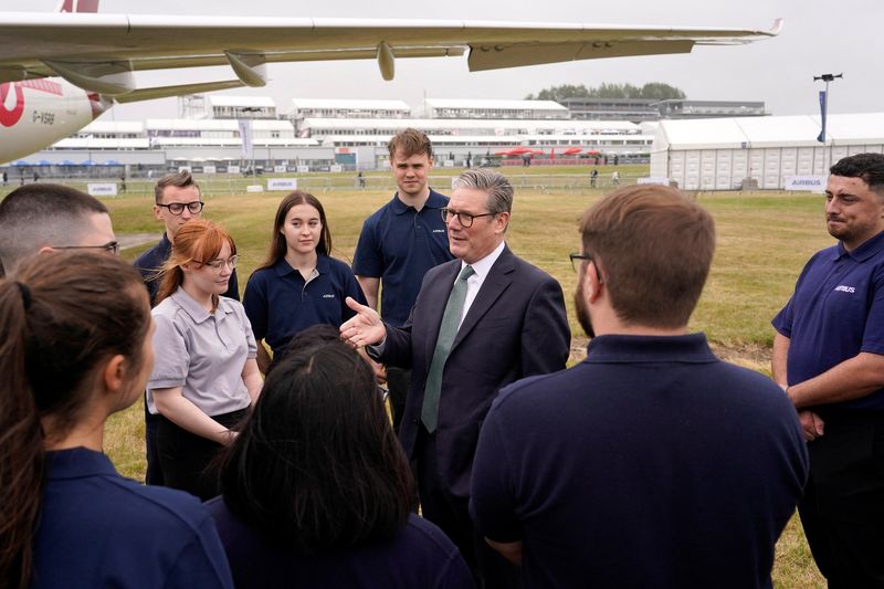 © Reuters. Britain's Prime Minister Keir Starmer speaks to employees as he arrives at the Farnborough International Airshow, July 22, 2024. Alberto Pezzali/Pool via REUTERS