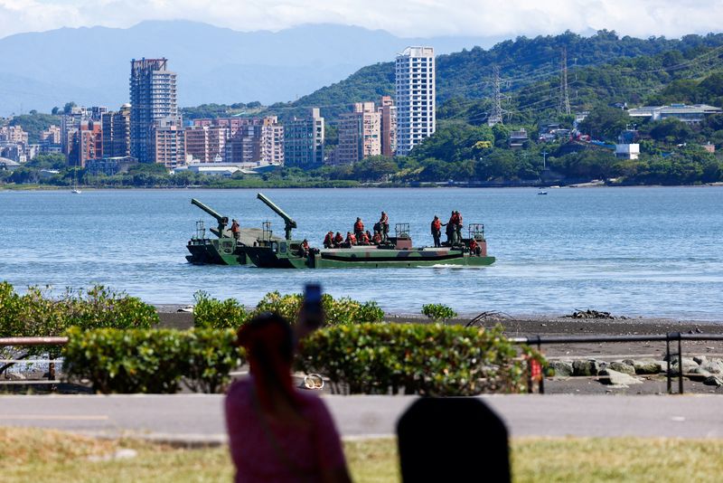 © Reuters. A woman watches as soldiers practice laying mines and nets to stymie the landing of enemy forces at the mouth of a major river leading to the city in Taipei, Taiwan July 22, 2024. REUTERS/Ann Wang