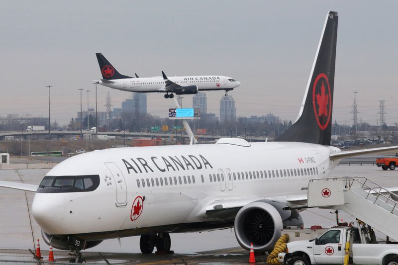 © Reuters. FILE PHOTO: An Air Canada Boeing 737 MAX 8 from San Francisco approaches for landing at Toronto Pearson International Airport over a parked Air Canada Boeing 737 MAX 8 aircraft in Toronto, Ontario, Canada, March 13, 2019.  REUTERS/Chris Helgren/File Photo