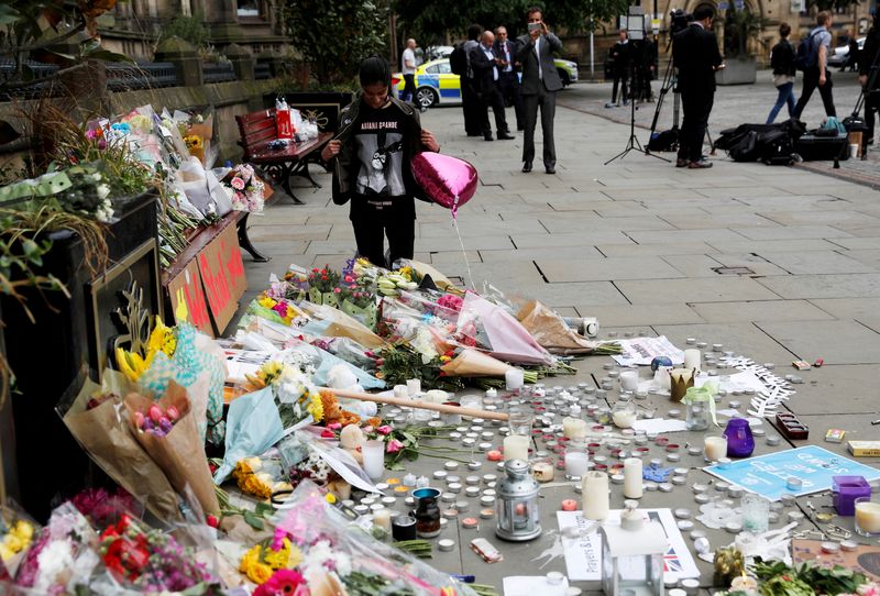 © Reuters. FILE PHOTO: An Ariana Grande fan stands next to floral tributes left for the victims of an attack on concert goers at Manchester Arena, in St Ann's Square, in Manchester, Britain May 24, 2017. REUTERS/Darren Staples/File Photo