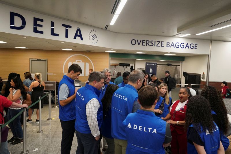 © Reuters. Delta employees show up to help out as people wait to retrieve their luggage after long delays following cyber outages affecting airlines at Hartsfield-Jackson Atlanta International Airport in Atlanta, Georgia, U.S., July 22, 2024.   REUTERS/Megan Varner