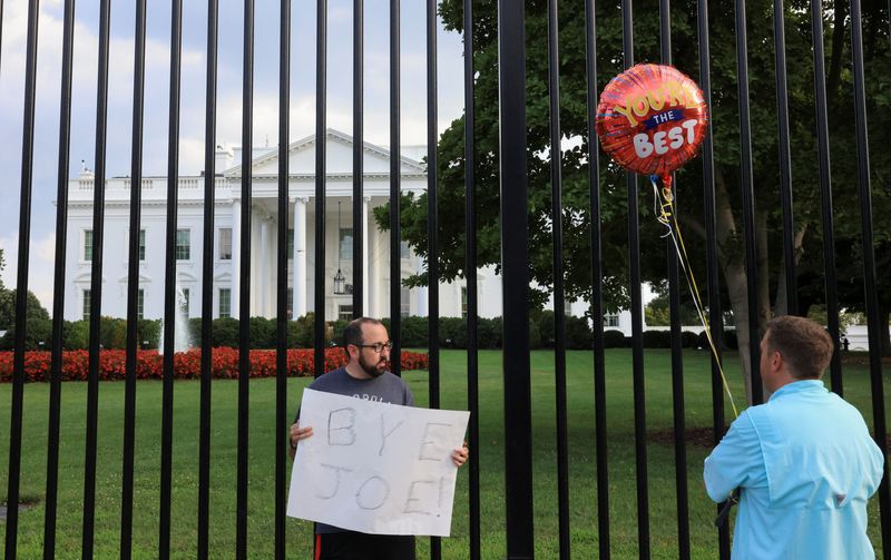 © Reuters. FILE PHOTO: A person holds a placard as people gather outside the White House after U.S. President Joe Biden announced he is stopping his bid for reelection, in Washington, D.C., U.S., July 21, 2024. REUTERS/Kevin Mohatt/File Photo