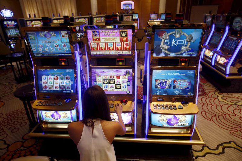 &copy; Reuters. FILE PHOTO: A casino trainee demonstrates how to play a slot machine in the  Philippines, April 16, 2015. REUTERS/Erik De Castro/File Photo