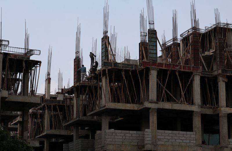 © Reuters. FILE PHOTO: Workers fasten iron rods together at the construction site of a residential building of Pradhan Mantri Awas Yojana in Ahmedabad, India, July 18, 2024. REUTERS/Amit Dave/File Photo