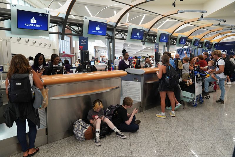 © Reuters. FILE PHOTO: People speak to Delta agents as they try to rebook their travel plans after long delays following cyber outages affecting airlines at Hartsfield-Jackson Atlanta International Airport in Atlanta, Georgia, U.S., July 22, 2024.   REUTERS/Megan Varner/File Photo