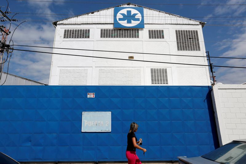 &copy; Reuters. Mulher caminha em frente a prédio da Kimberly-Clark em Maracay, na Venezuelan10/07/2016 REUTERS/Carlos Jasso