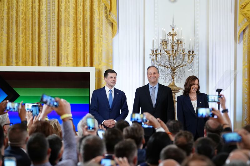 © Reuters. FILE PHOTO: U.S. Secretary of Transportation Pete Buttigieg, U.S. second gentleman Doug Emhoff and Vice President Kamala Harris attend a Pride Month event in the East Room of the White House in Washington, U.S., June 15, 2022. REUTERS/Sarah Silbiger/File Photo