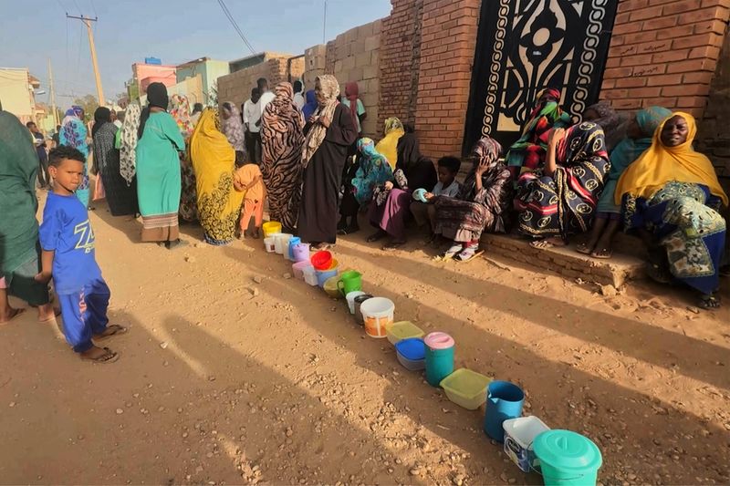 © Reuters. FILE PHOTO: Residents wait to collect food in containers from a soup kitchen in Omdurman, Sudan March 11, 2024. REUTERS/El Tayeb Siddig/File Photo