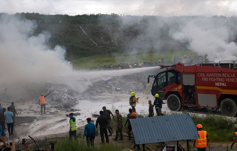 © Reuters. Firefighters work at the site where a Saurya Airlines plane caught fire after skidding off the runway while taking off at Tribhuvan International Airport, in Kathmandu, Nepal, July 24, 2024.  REUTERS/Stringer