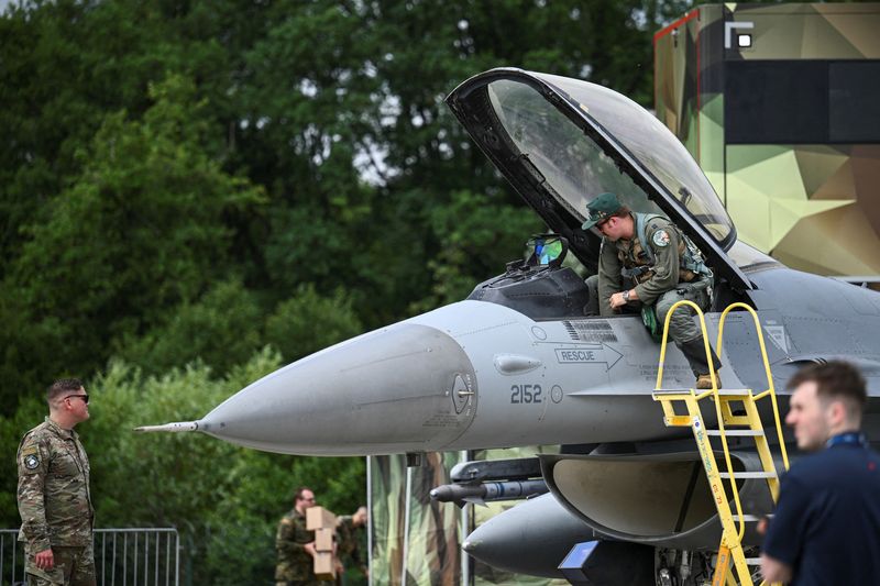 © Reuters. FILE PHOTO: A man gets off the General Dynamics F-16 Fighting Falcon, a United States Air Force fighter after it gets parked ahead of the opening of the International Aerospace Exhibition ILA in Berlin, Germany June 4, 2024. REUTERS/Annegret Hilse/File Photo