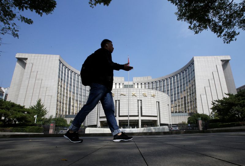 © Reuters. FILE PHOTO: A man walks past the headquarters of the People's Bank of China (PBOC), the central bank, in Beijing, China September 28, 2018. REUTERS/Jason Lee