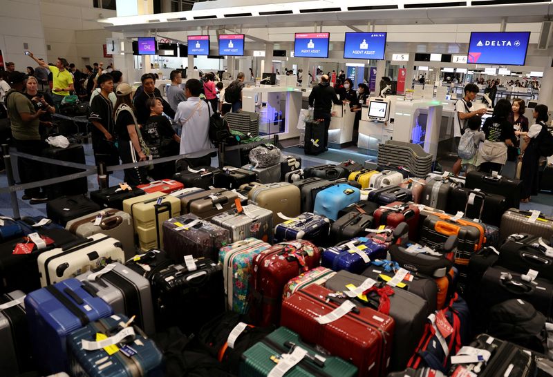 &copy; Reuters. FILE PHOTO: Passengers stands in a line at Delta Airlines’ counter following a global IT outage, at Haneda International Airport in Tokyo, Japan July 19,  2024. REUTERS/Kim Kyung-Hoon/File Photo