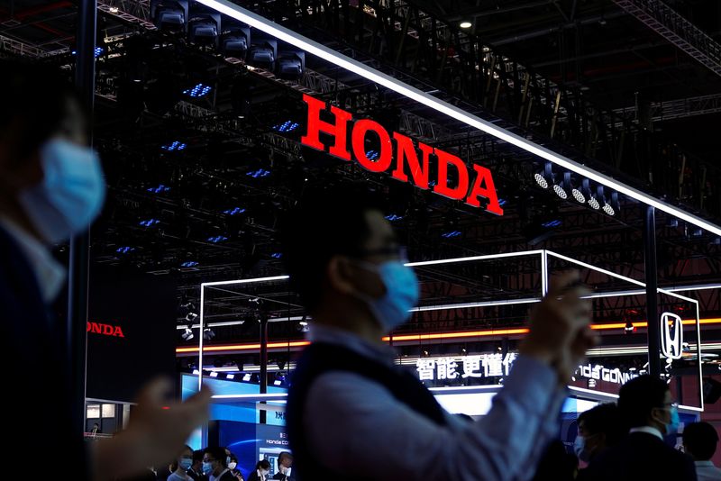 © Reuters. FILE PHOTO: Visitors stand near the Honda booth during a media day for the Auto Shanghai show in Shanghai, China April 19, 2021. REUTERS/Aly Song/File Photo