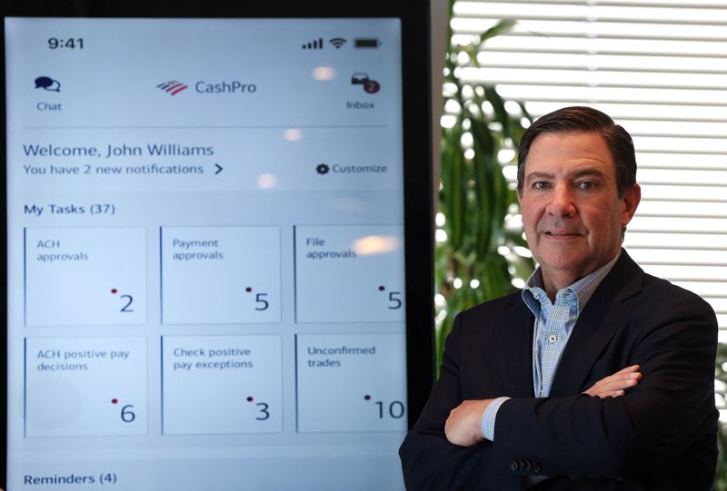 © Reuters. Mark Monaco, head of Global Payments Solutions at Bank of America, poses with a display of BofA’s CashPro app during an interview with Reuters in New York City, U.S., March 21, 2024. REUTERS/Mike Segar