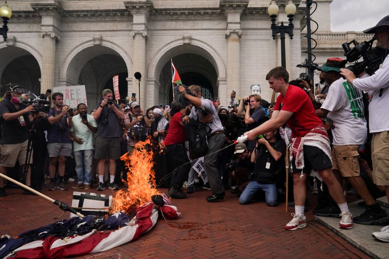 © Reuters. FILE PHOTO: Pro-Palestinian demonstrators burn a U.S. flag, on the day of Israeli Prime Minister Benjamin Netanyahu's address to a joint meeting of Congress, on Capitol Hill in Washington, U.S., July 24, 2024. REUTERS/Nathan Howard/File Photo