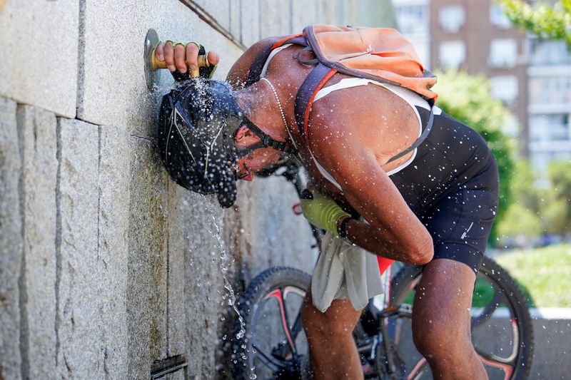 © Reuters. A cyclist cools off at a fountain at Madrid Rio park during the second day of the heatwave, in Madrid, Spain, July 25, 2024. REUTERS/Ana Beltran