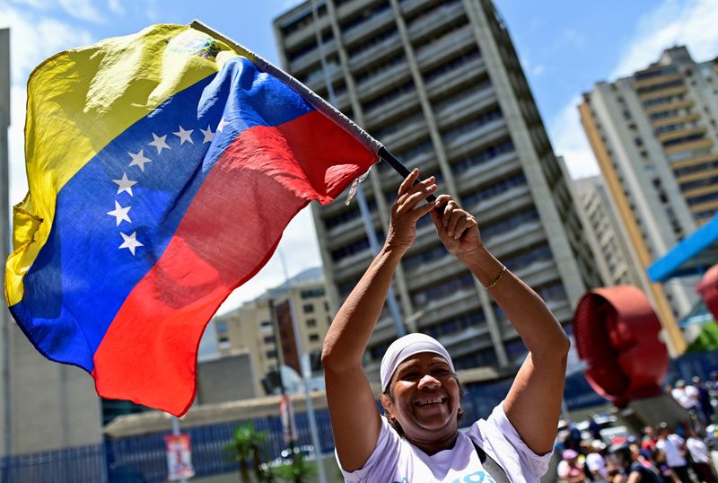 © Reuters. A supporter of Venezuela's President Nicolas Maduro waves Venezuela's national flag while gathering with fellow supporters for the closing of Maduro's political campaign who is seeking reelection for a third term, in Caracas, Venezuela July 25, 2024. REUTERS/Maxwell Briceno