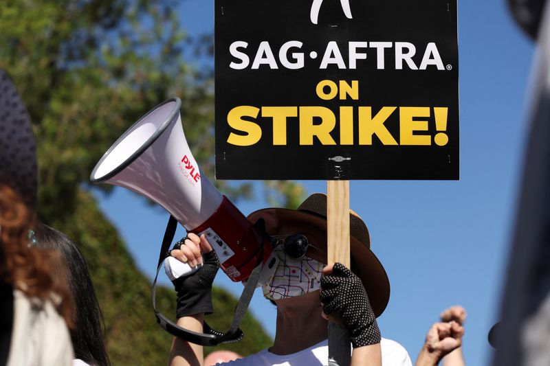 &copy; Reuters. FILE PHOTO: A person holds a sign as SAG-AFTRA actors and Writers Guild of America (WGA) writers walk the picket line during their ongoing strike outside Walt Disney Studios in Burbank, California, U.S., August 22, 2023. REUTERS/Mario Anzuoni/File Photo