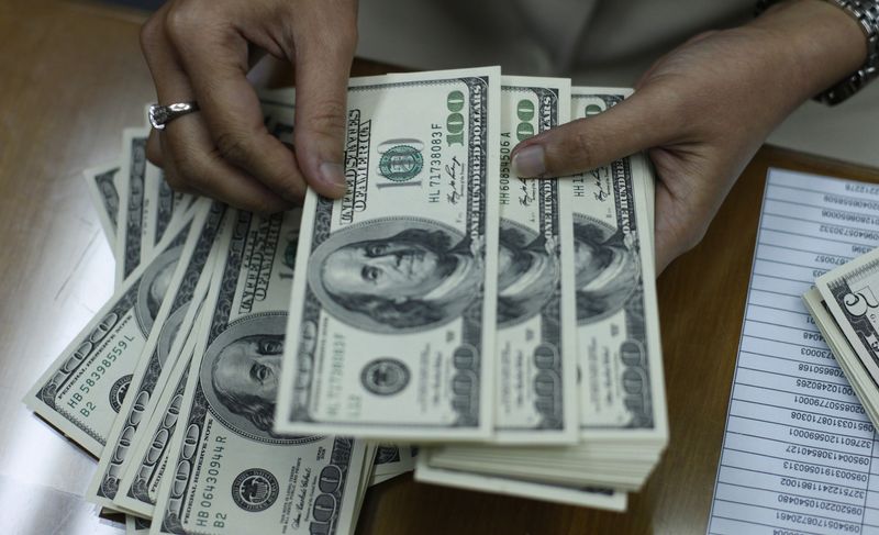 &copy; Reuters. Un'impiegata conta le banconote in dollari in un cambiavalute di Giacarta il 27 gennaio 2010. REUTERS/Beawiharta