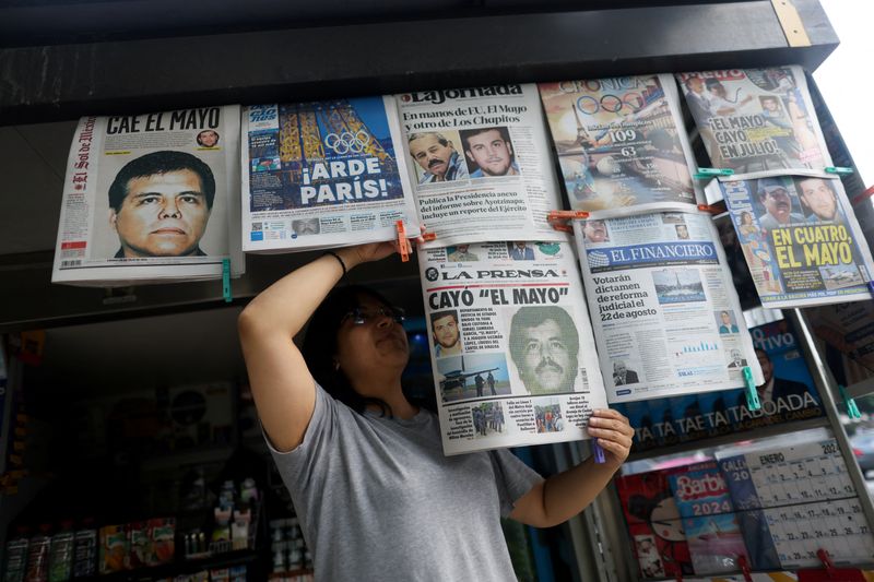 © Reuters. A newspaper seller arranges newspapers reporting the El Paso, Texas, U.S., arrest of Mexican drug lord Ismael 