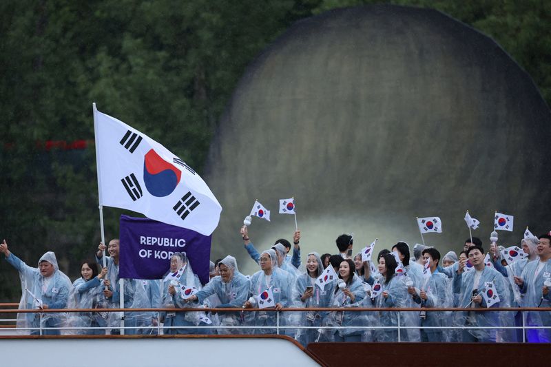 © Reuters. FILE PHOTO: Paris 2024 Olympics - Opening Ceremony - Paris, France - July 26, 2024. Athletes of South Korea aboard a boat in the floating parade on the river Seine during the opening ceremony. REUTERS/Claudia Greco/File Photo