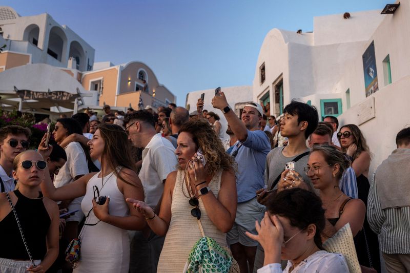 © Reuters. Tourists view Santorini’s famed sunset, on Santorini, Greece, July 25, 2024. REUTERS/Alkis Konstantinidis