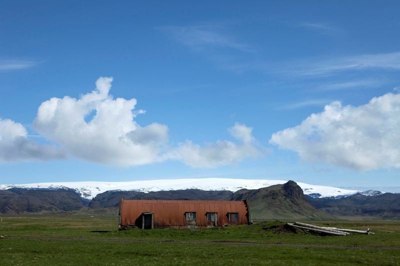 &copy; Reuters. FILE PHOTO: A farm building stands in a field below the Myrdalsjokull glacier that covers the Katla volcano in Evindarholar, Iceland May 28, 2011. REUTERS/Lucas Jackson/File Photo