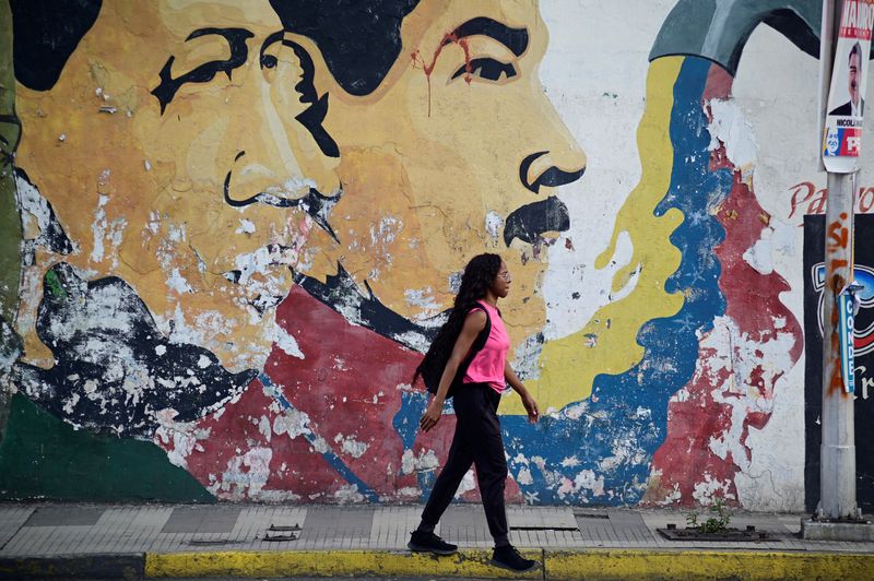 &copy; Reuters. A woman walks past a mural depicting late former Venezuelan President Hugo Chavez and Venezuelan President Nicolas Maduro in Caracas, Venezuela July 27, 2024. REUTERS/Maxwell Briceno