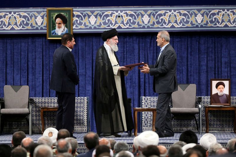 &copy; Reuters. Iran's Supreme Leader Ayatollah Ali Khamenei gives a Presidential decree to Iran's new president, Masoud Pezeshkian, during an endorsement ceremony in Tehran, Iran, July 28, 2024. Office of the Iranian Supreme Leader/WANA (West Asia News Agency)/Handout v