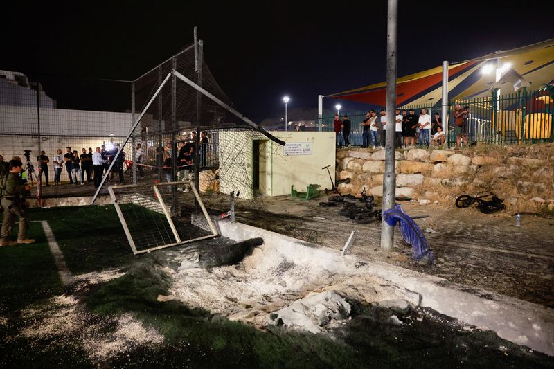 &copy; Reuters. Israeli officials respond after rockets were launched across Lebanon's border with Israel which, according to Israel's ambulance services, people were killed, at a soccer pitch in Majdal Shams, a Druze village in the Israeli-occupied Golan Heights, July 2