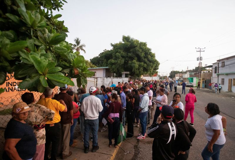 © Reuters. People stand in line outside a polling station to cast their votes in Venezuela's presidential election, in Barcelona, Venezuela July 28, 2024. REUTERS/Samir Aponte