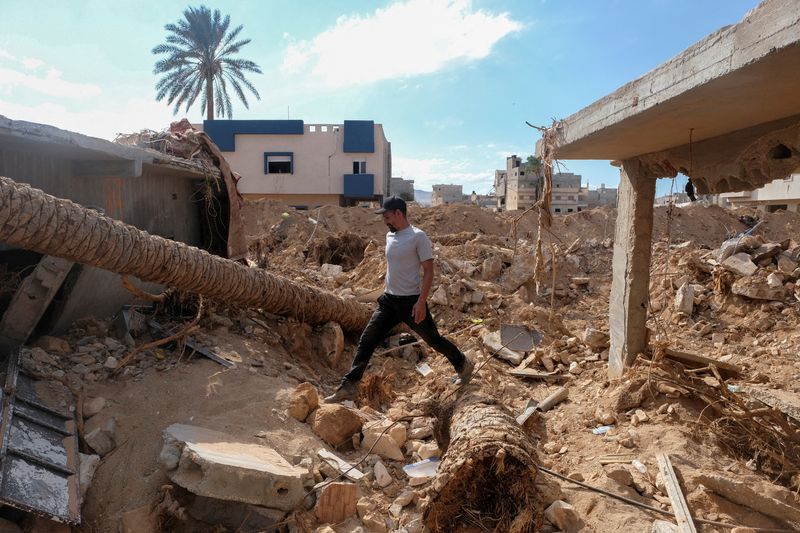 &copy; Reuters. FILE PHOTO: Abdul Salam Ibrahim Al-Qadi, 43 years old, walks on the rubble in front of his house, searching for his missing father and brother after the deadly floods in Derna, Libya, September 28, 2023. REUTERS/Esam Omran Al-Fetori/File Photo