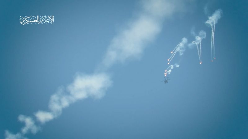 © Reuters. An Israeli military helicopter releases flares, amid the Israel-Hamas conflict, at a location given as Gaza, in this still image taken from video released July 27, 2024. Hamas Military Wing/Handout via REUTERS