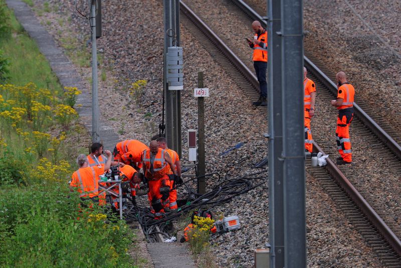 © Reuters. FILE PHOTO: SNCF railway workers and law enforcement officers work at the site where vandals targeted France's high-speed train network with a series of coordinated actions that brought major disruption, ahead of the Paris 2024 Olympics opening ceremony, in Croisilles, northern France  July 26, 2024. REUTERS/Brian Snyder/File Photo