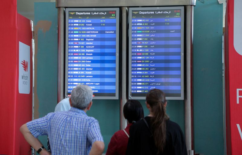 &copy; Reuters. Persone osservano i tabelloni informativi dei voli all'aeroporto internazionale di Beirut-Rafic Hariri, a Beirut, in Libano, il 28 luglio 2024. REUTERS/Mohamed Azakir