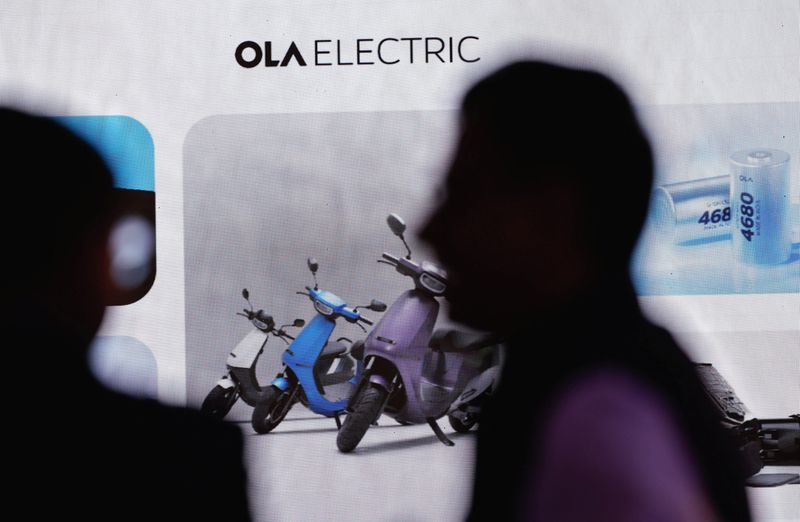 © Reuters. People talk in front of the Ola Electric logo during a press conference ahead of it's IPO launch in Mumbai, India, July 29, 2024. REUTERS/Francis Mascarenhas