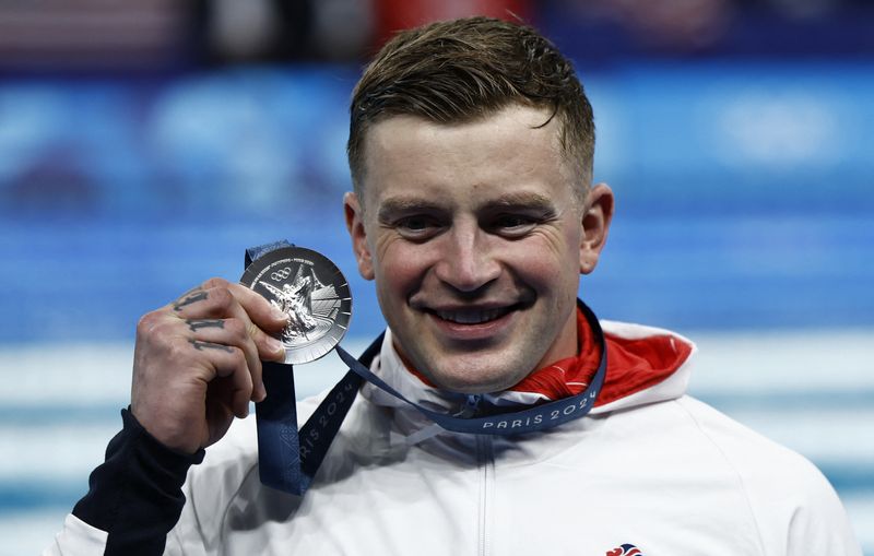 &copy; Reuters. Olimpiadi di Parigi 2024 - Nuoto - Cerimonia di vittoria nei 100 m rana maschile - Paris La Defense Arena, Nanterre, Francia - 28 luglio 2024.  Il britannico Adam Peaty, medaglia d'argento, festeggia. REUTERS/Clodagh Kilcoyne/Foto d'archivio