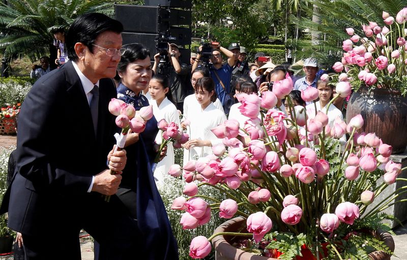 © Reuters. FILE PHOTO: Former Vietnamese President Truong Tan Sang and his wife Mai Thi Hanh lay flower during the 50th anniversary of the My Lai massacre in My Lai village, Vietnam March 16, 2018. REUTERS/Kham/File Photo