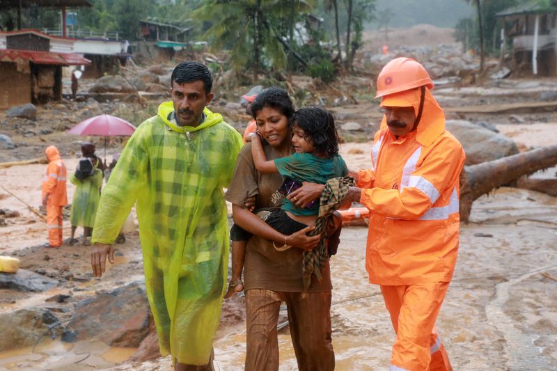 &copy; Reuters. Rescuers help residents to move to a safer place, at a landslide site after multiple landslides in the hills, in Wayanad, in the southern state of Kerala, India, July 30, 2024. REUTERS/Stringer