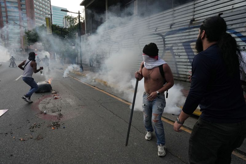 &copy; Reuters. Protesters run to take cover from tear gas as Venezuelan opposition supporters protest following the announcement by the National Electoral Council that Venezuela's President Nicolas Maduro won the presidential election, in Caracas, Venezuela July 29, 202