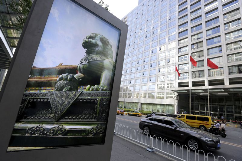 &copy; Reuters. FILE PHOTO: An advertising board (L) showing a Chinese stone lion is pictured near an entrance to the headquarters (R) of China Securities Regulatory Commission (CSRC), in Beijing, China, September 7, 2015. REUTERS/Jason Lee/File Photo