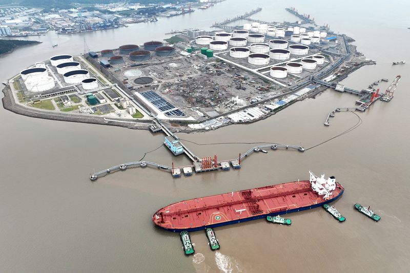 &copy; Reuters. Una veduta aerea mostra i rimorchiatori che aiutano una petroliera ad attraccare in un terminal petrolifero, al largo dell'isola di Waidiao a Zhoushan, nella provincia di Zhejiang, in Cina, il 18 luglio 2022. cnsphoto via REUTERS