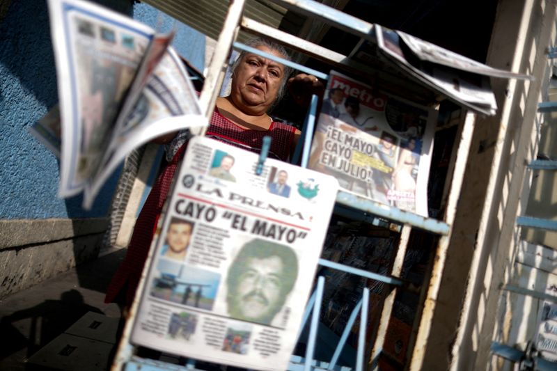 © Reuters. FILE PHOTO: A newspaper seller arranges newspapers reporting the El Paso, Texas, U.S., arrest of Mexican drug lord Ismael 