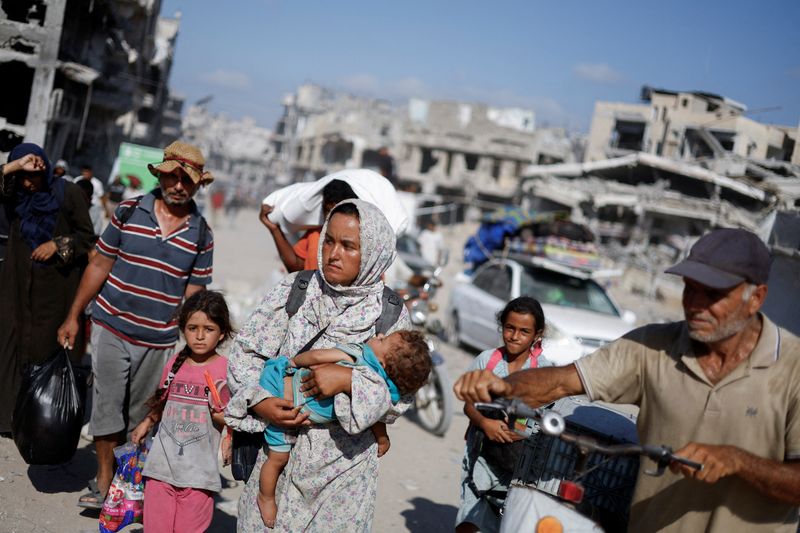 &copy; Reuters. Palestinians make their way to return to neighbourhoods in the eastern side of Khan Younis after Israeli forces pulled out from the area, amid the Israel-Hamas conflict, in Khan Younis, in the southern Gaza Strip July 30, 2024. REUTERS/Mohammed Salem     