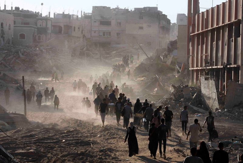 © Reuters. Palestinians make their way as they return to the eastern side of Khan Younis after Israeli forces pulled out from the area following a raid, amid the Israel-Hamas conflict, in Khan Younis, in the southern Gaza Strip July 30, 2024. REUTERS/Hatem Khaled    